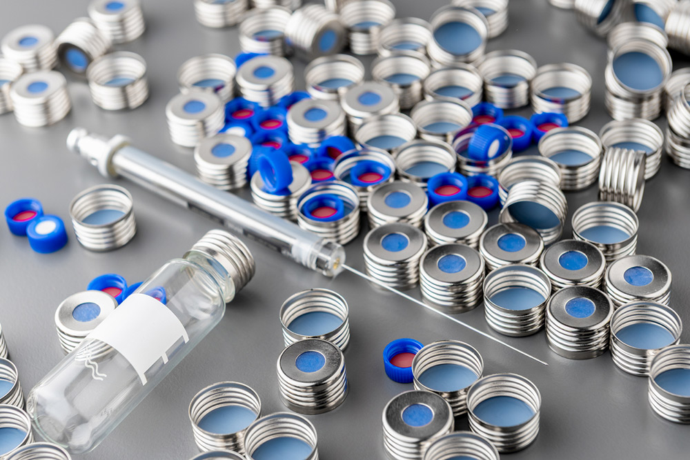 Crimp caps with PTFE-lined septa, glass vial, and syringe needle