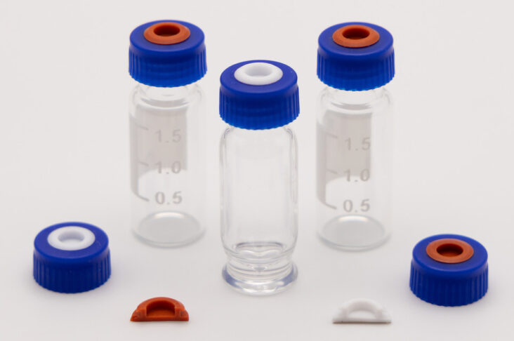 Blue screw caps with red and white septa displayed with glass sample vials and molded liner inserts