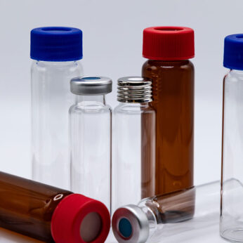 Assorted clear and amber glass sample vials with red, blue, and silver caps