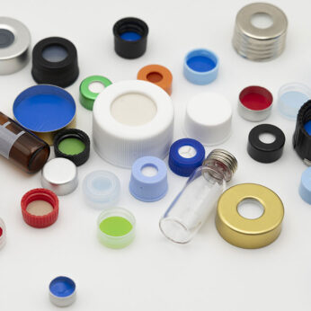 A scattered assortment of colorful laboratory vial caps, septa, and small glass vials